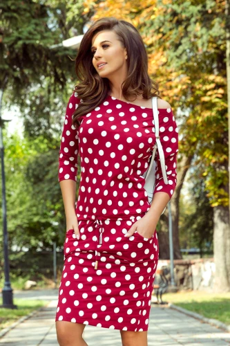 Eine sportliche, rote Kleid mit weißen Punkten und Dreiviertelärmeln, das lässig und stilvoll wirkt. Es hat praktische Taschen und einen Kordelzug in der Taille für eine bequeme Passform.}