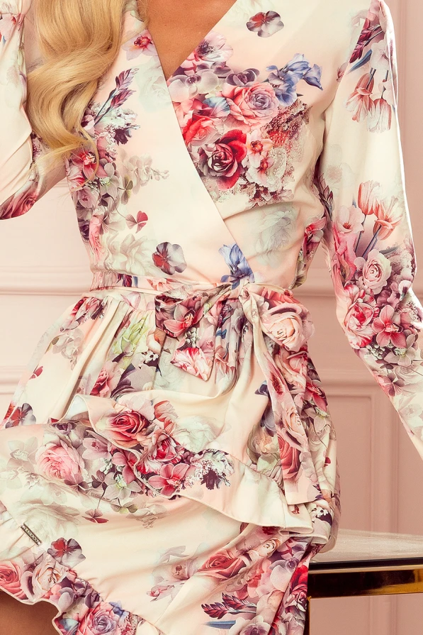 Elegantes Kleid mit floralen Mustern in zarten Rosa- und Lilatönen, das eine feminine und romantische Ausstrahlung verleiht. Der Wickelschnitt und die Rüschen betonen die Taille und sorgen für einen stilvollen Look.