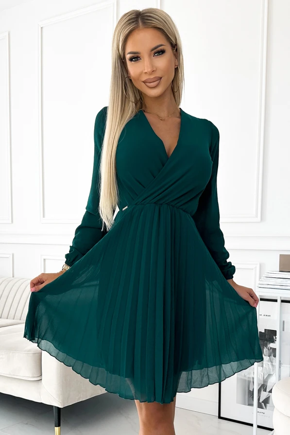 Elegantes, smaragdgrünes Kleid mit langen Ärmeln und einem V-Ausschnitt, das durch seinen fließenden, plissierten Rock besticht. Perfekt für besondere Anlässe, kombiniert es Stil mit einem Hauch von Raffinesse.