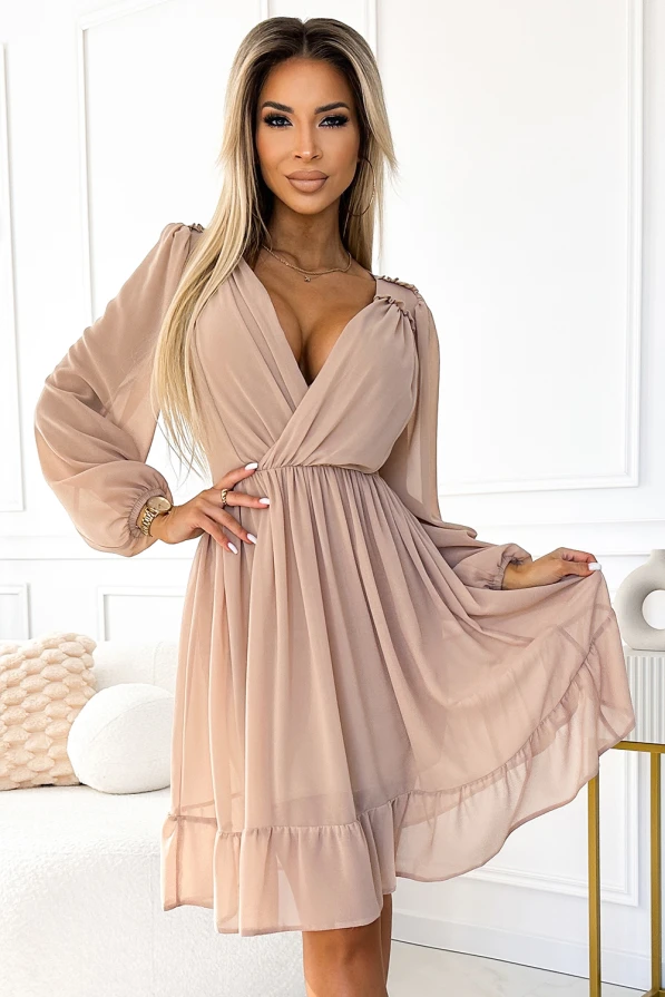 Eine elegante, beige Chiffonkleid mit langen Ärmeln und einem fließenden Rock, ideal für besondere Anlässe. Der tiefe V-Ausschnitt und die zarten Raffungen verleihen dem Kleid eine feminine Note.