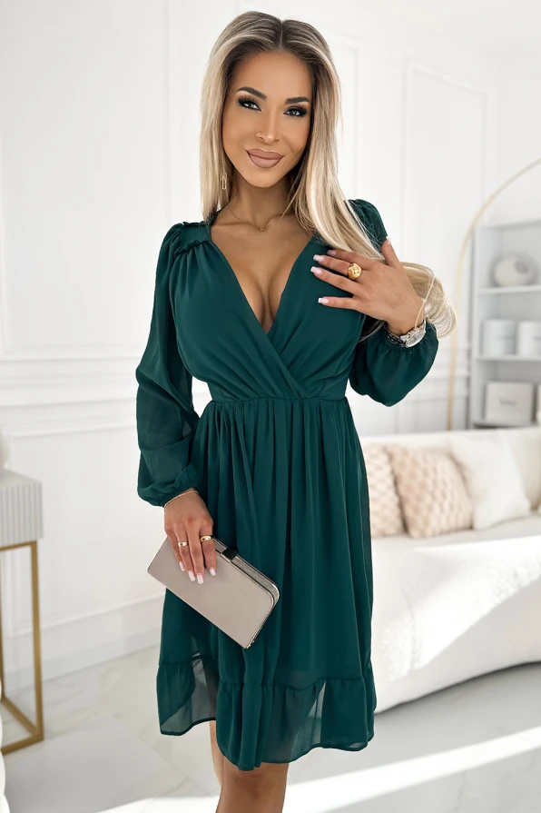 Elegantes, smaragdgrünes Chiffonkleid mit tiefem V-Ausschnitt und langen Ärmeln. Perfekt für besondere Anlässe, kombiniert mit einer dezenten Clutch.