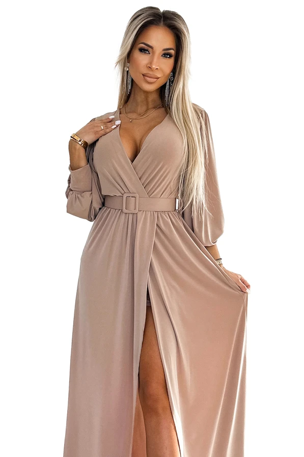 Elegantes, langes Kleid in einem sanften Beigeton mit tiefem V-Ausschnitt und einem stilvollen Gürtel in der Taille. Die fließenden Ärmel und der hohe Schlitz verleihen dem Kleid eine raffinierte Note.