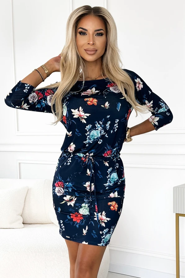 Elegantes, sportliches Kleid mit floralem Muster in dunklen Farbtönen, das eine feminine Silhouette betont. Der Kordelzug in der Taille verleiht dem Kleid eine anpassbare Passform und einen lässigen Touch.
