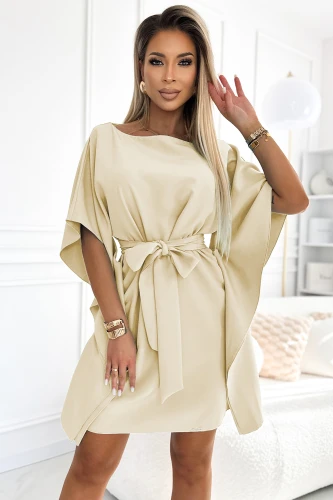 Elegantes cremefarbenes Kleid mit weitem Schnitt und einem dekorativen Gürtel, der die Taille betont. Perfekt für besondere Anlässe, kombiniert es Komfort mit einem stilvollen, modernen Look.}