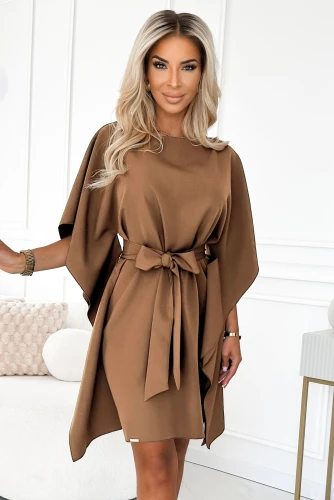 Modelka prezentuje elegancką sukienkę motyl w kolorze karmelowym z wiązaniem w pasie – stylowa propozycja marki Numoco, idealna na jesień.}