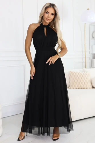 Model im schwarzen, langen Tüllkleid mit Halter-Ausschnitt und kleinem Tropfen-Ausschnitt, mit definierter Taille und luftigem, ausgestelltem Saum.}