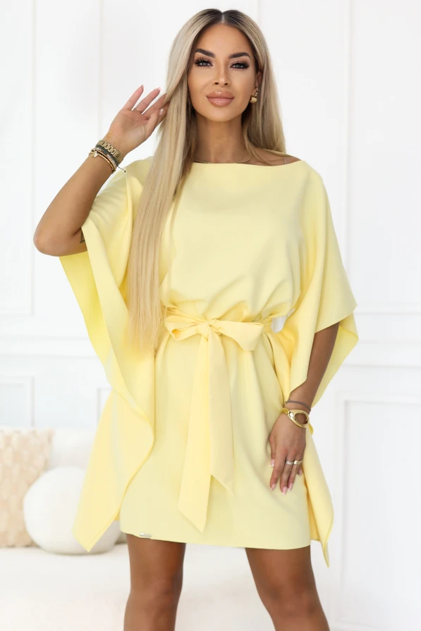 Das Model präsentiert das pastellfarbene Zitronen-Minikleid von Numoco mit weiten Kimono-Ärmeln und einer Taillenbindung, die die Figur wunderschön betont. Eine elegante, leichte Kreation – ideal für den Sommer, Partys und stilvolle Ausgänge.