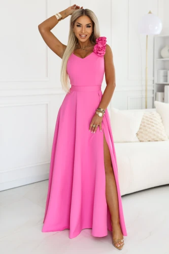 Elegantes langes Damen-Maxi-Kleid in Rosa, mit Beinschlitz, Herzausschnitt und einer dekorativen Blume auf der Schulter, polnische Produktion Numoco.}