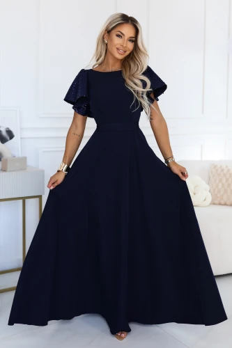 Model in einem marineblauen Maxikleid Numoco mit figurbetonter Taille, ausgestelltem Rock und schimmernden Schmetterlingsärmeln.}