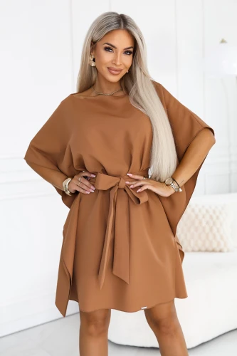 Model im Schmetterlingskleid von Numoco in Toffee mit weiten Ärmeln, Bootausschnitt und in der Taille gebundenem Gürtel, knapp über dem Knie.}