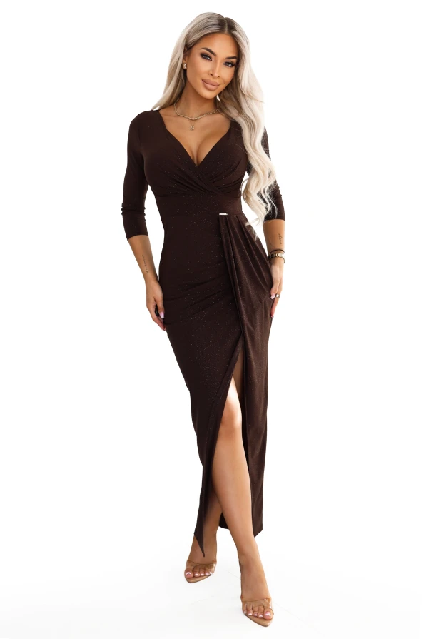 Model im schokoladenbraunen Numoco Maxikleid mit Glitzerschimmer, Wickelausschnitt, 3/4-Ärmeln, Drapierung in der Taille und Schlitz vorn.