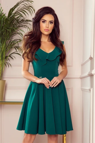 Elegantes, smaragdgrünes Kleid mit V-Ausschnitt und zarten Rüschen, das eine feminine Silhouette betont. Der ausgestellte Rock verleiht dem Kleid eine verspielte Note und sorgt für einen stilvollen Auftritt.}