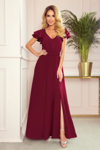 Langes, elegantes Kleid in tiefem Burgunderrot mit kurzen, gerüschten Ärmeln und einem seitlichen Schlitz. Der fließende Stoff und der taillierte Schnitt betonen die feminine Silhouette.}
