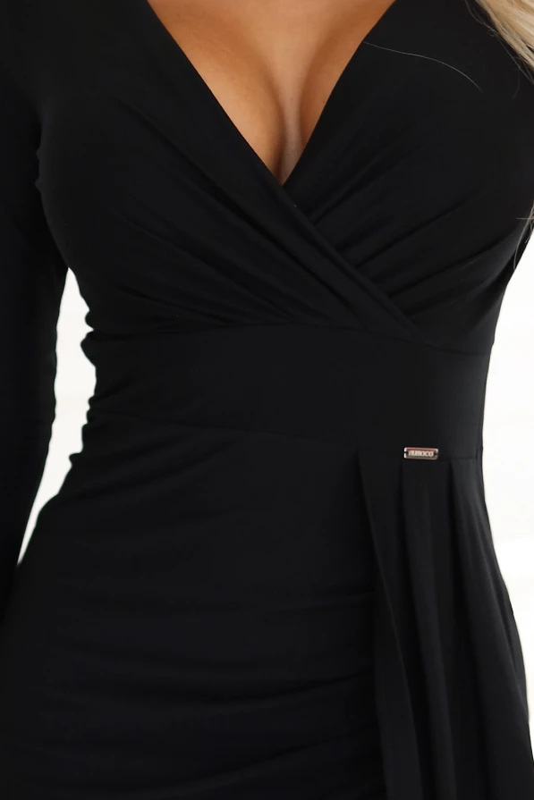 Modelka prezentuje elegancką czarną długą suknię z dekoltem i rozcięciem na nodze marki Numoco – idealną kreację na wieczorne wyjścia.