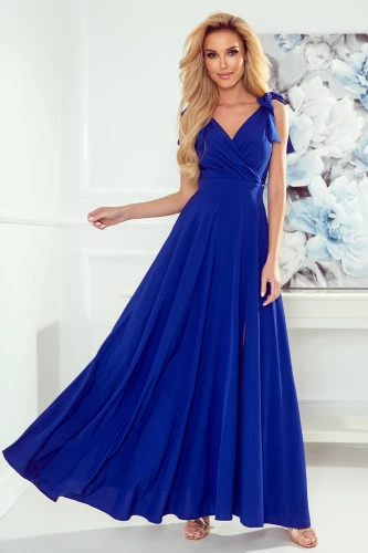 Elegantes, langes Kleid in kräftigem Blau mit einem schmeichelhaften V-Ausschnitt und zarten Schleifendetails an den Schultern. Der fließende Stoff und der seitliche Schlitz verleihen dem Kleid eine anmutige Silhouette.}
