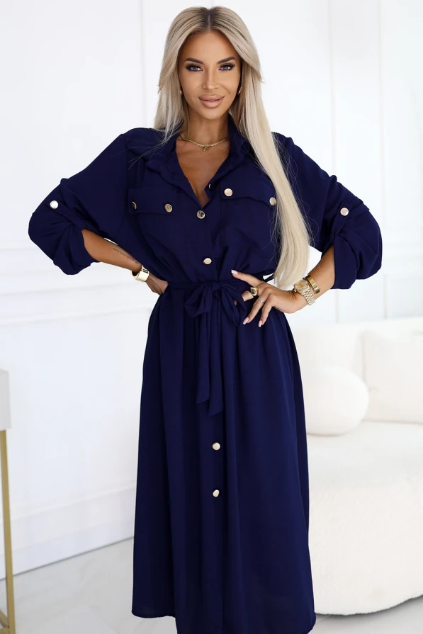 Modelka w granatowej szmizjerce z paskiem i złotymi guzikami – elegancka sukienka koszulowa marki Numoco Basic, idealna na co dzień i do pracy.