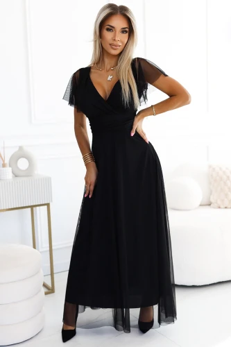 Langes, elegantes schwarzes Kleid mit transparenten Ärmeln und einem fließenden Rock, ideal für formelle Anlässe. Der V-Ausschnitt und die taillierte Passform betonen die feminine Silhouette.}