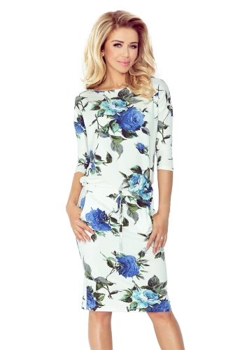 Eine elegante, cremefarbene Sportkleid mit blauen Rosenmuster und dreiviertellangen Ärmeln. Der lockere Schnitt und der Kordelzug in der Taille verleihen dem Kleid eine lässige und stilvolle Note.}