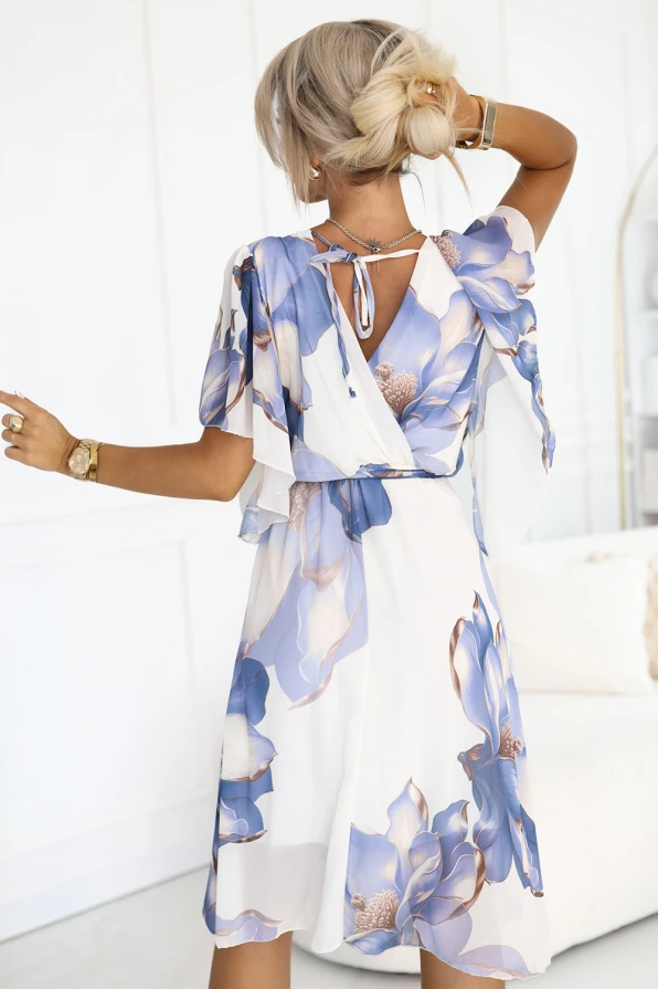 Romantyczna sukienka Numoco Basic z kopertowym dekoltem, zwiewnymi rękawkami i błękitnym kwiatowym wzorem na białym tle, idealna na lato, randki i wakacyjne wyjścia. Produkcja europejska, lekki i kobiecy fason.