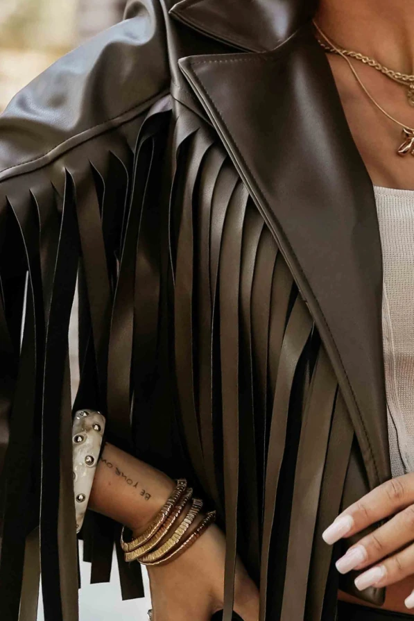 Modelka pozuje w efektownej ramonesce z frędzlami w kolorze czekoladowym, podkreślając nowoczesny styl i kobiecy charakter produktu Numoco.