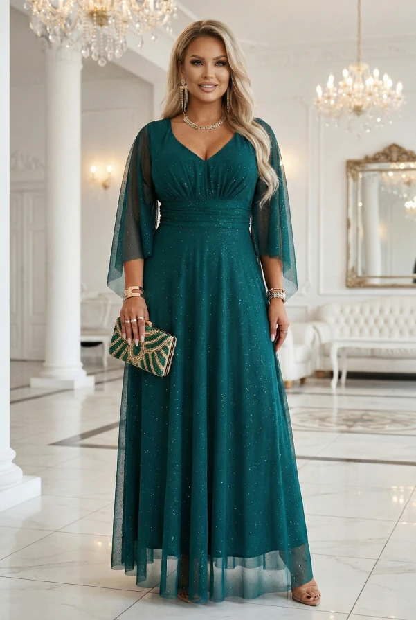 Modelka w szmaragdowej wieczorowej sukience plus size maxi z brokatowym połyskiem i rękawami typu motyl w jasnym wnętrzu.