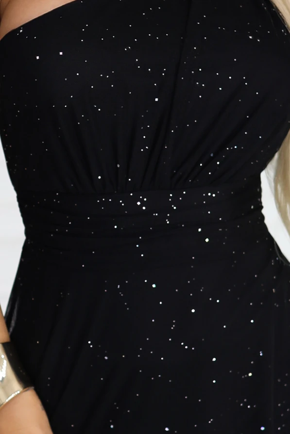 Tył czarnej brokatowej sukienki maxi na jedno ramię Numoco Basic, wiązanie w talii i zwiewna spódnica