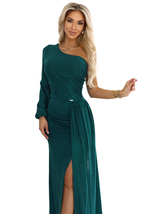 Zielona połyskująca sukienka maxi na jedno ramię z długim rękawem i wysokim rozcięciem – kreacja na wesele i bal od polskiej marki Numoco.